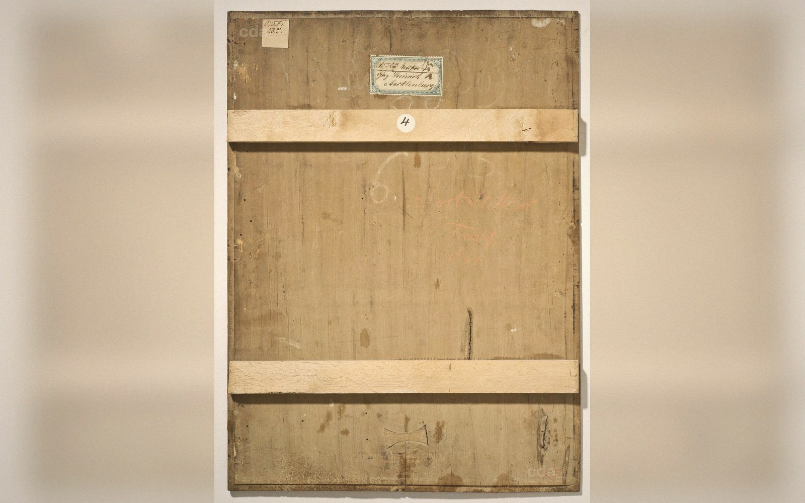 Reverse of a wooden panel painting showing cross battens, an inventory label, and handwritten numbers