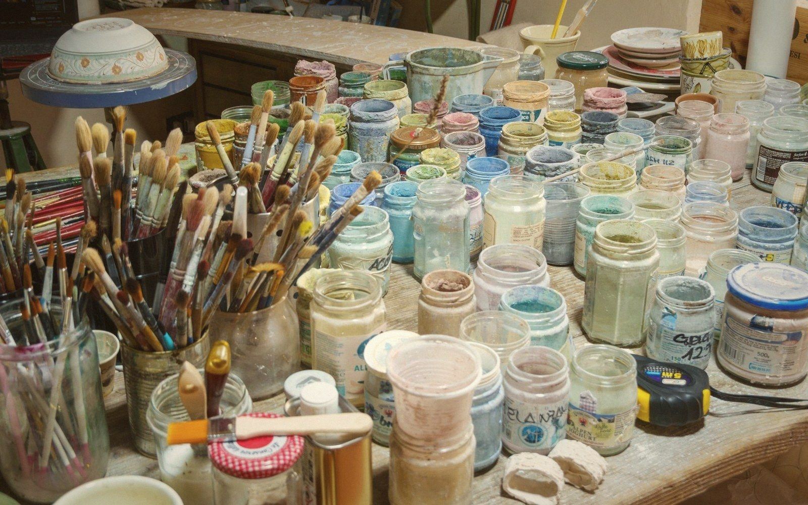 A conservator's tray of pigment jars and small brushes